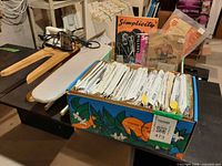 Overview showing sleeve board, steam iron, and box of patterns