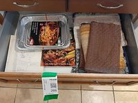 Drawer view showing lasagna pan, cookbooks and folded linens