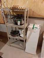 Front view of assembled shelving holding example items; connecting poles on top