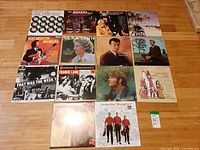 All 14 LPs laid out in four rows on floor