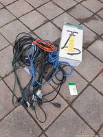 Boxed double-action hand pump and bundle of cables on ground