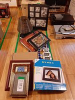 Top-down view of entire lot showing Dynex box, stack of frames, photo albums and wire vase