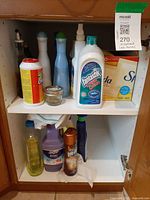 Upper and lower cupboard shelves showing all cleaners