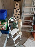 Step stool, tower fan, ironing board, hanger stacker visible together