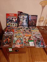 All items laid out on desk showing trades, magazine, sticker album and True Believers issues