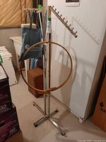 Overall view of chrome garment rack with wooden hoop and tote
