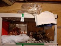 Shelf with boxed nativity set, quilt, batting and desert houses visible