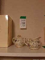 Lenox box next to sugar bowl and creamer set on shelf