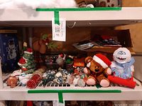 Shelf with entire assortment including Pooky bear, Bumble snowman, string lights, bead garlands, ornaments