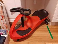 Side view of red and black PlasmaCar showing overall shape and steering wheel