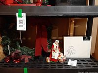 Figurine, wreath, box shown on shelf