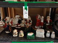 Shelf view showing all Santa figurines and smaller tableware pieces