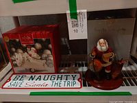 All three items on shelf: boxed Lenox figurine, Santa with globe, metal sign