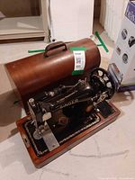 Singer sewing machine on wood base with bentwood cover open