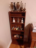 Front view of brown wooden narrow bookcase showing shelves and contents (contents excluded)