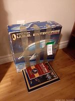 Boxed Polar Lights U.S.S. Enterprise kit with books stacked beneath