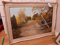 Full view of framed painting leaning against wall