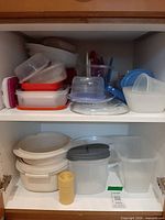 Full view of both shelves showing assortment of plastic containers and lids