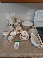 Overview of assorted vintage ceramic and glass tableware on countertop