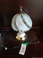 Full lamp with shade, cord and finial visible