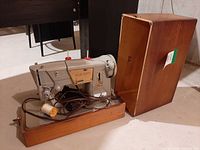 Singer 328K sewing machine in wood base, cover removed, cords visible