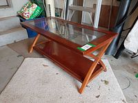 full perspective view of table showing glass top, wooden frame and lower shelf