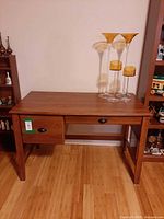 Front view of dark brown wooden desk showing drawers and legs