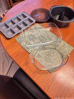 Entire lot showing mini loaf pan, two glass dishes, Bundt pan, speckled pan