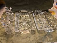 Two crystal swan candlesticks and two rectangular crystal pickle trays on table