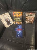 Group shot of four DVD sets on leather surface