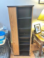 Rotating media tower front view showing shelves and two-tone finish