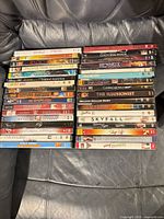 Two stacks of DVD cases on a leather surface