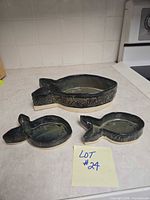 Overview of all three fish-shaped ceramic bowls on countertop