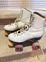 Side view of both white leather quad skates on stair tread