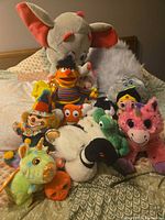 Full group of stuffed animals on bed