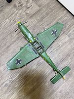 Full underside view of green metal model plane showing crosses and wing shape