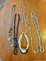 All six necklaces laid out on table