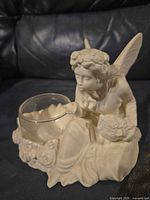 Front view of ivory resin fairy candle holder with glass bowl