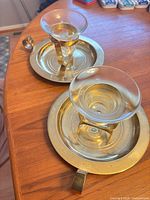 Two brass and glass votive holders on table