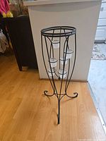 full height view of black metal stand with glass cups installed