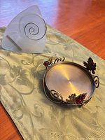 Wall sconce and grape motif pillar stand on fabric runner