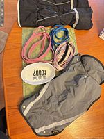 Overview of all items on table: two coats, three leashes, ceramic food bowl