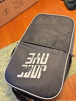 Closed black JoncAye carrying case with logo on tabletop