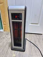 Front view of ceramic tower heater showing grille, display off