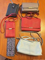 Group shot of all six purses and wallets on tabletop