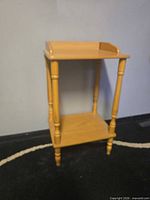 Full view of light wood side table showing top, legs, and shelf