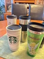 Group shot of four travel mugs showing designs and sizes
