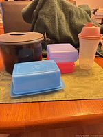 Lot overview showing rice cooker, sandwich keepers, butter dish, shaker