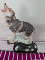 Front view of resin howling wolf figurine on base