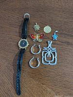 All items laid out on table: watch, earrings, pendants